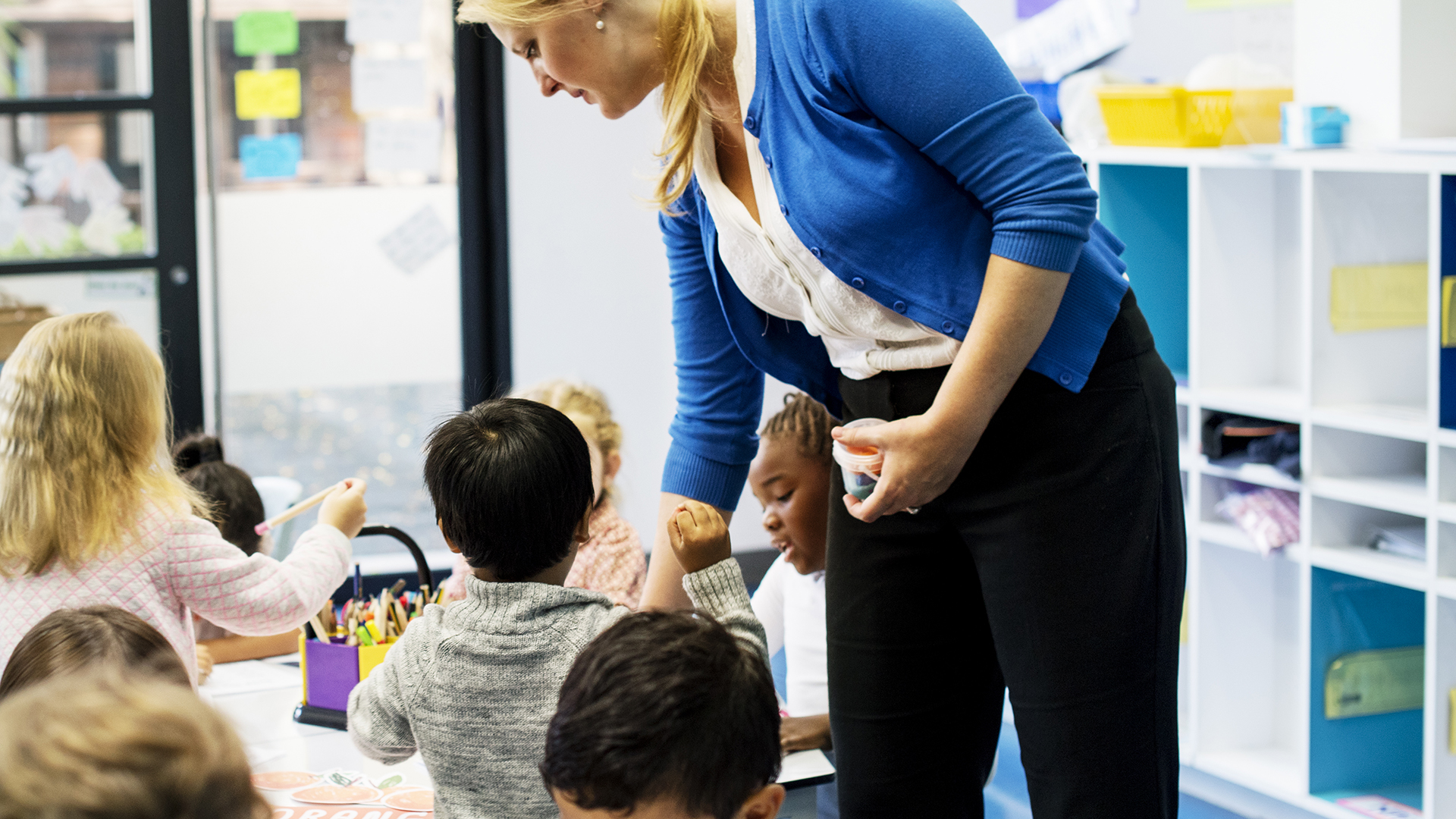 Image of a group of children colouring workbook in class