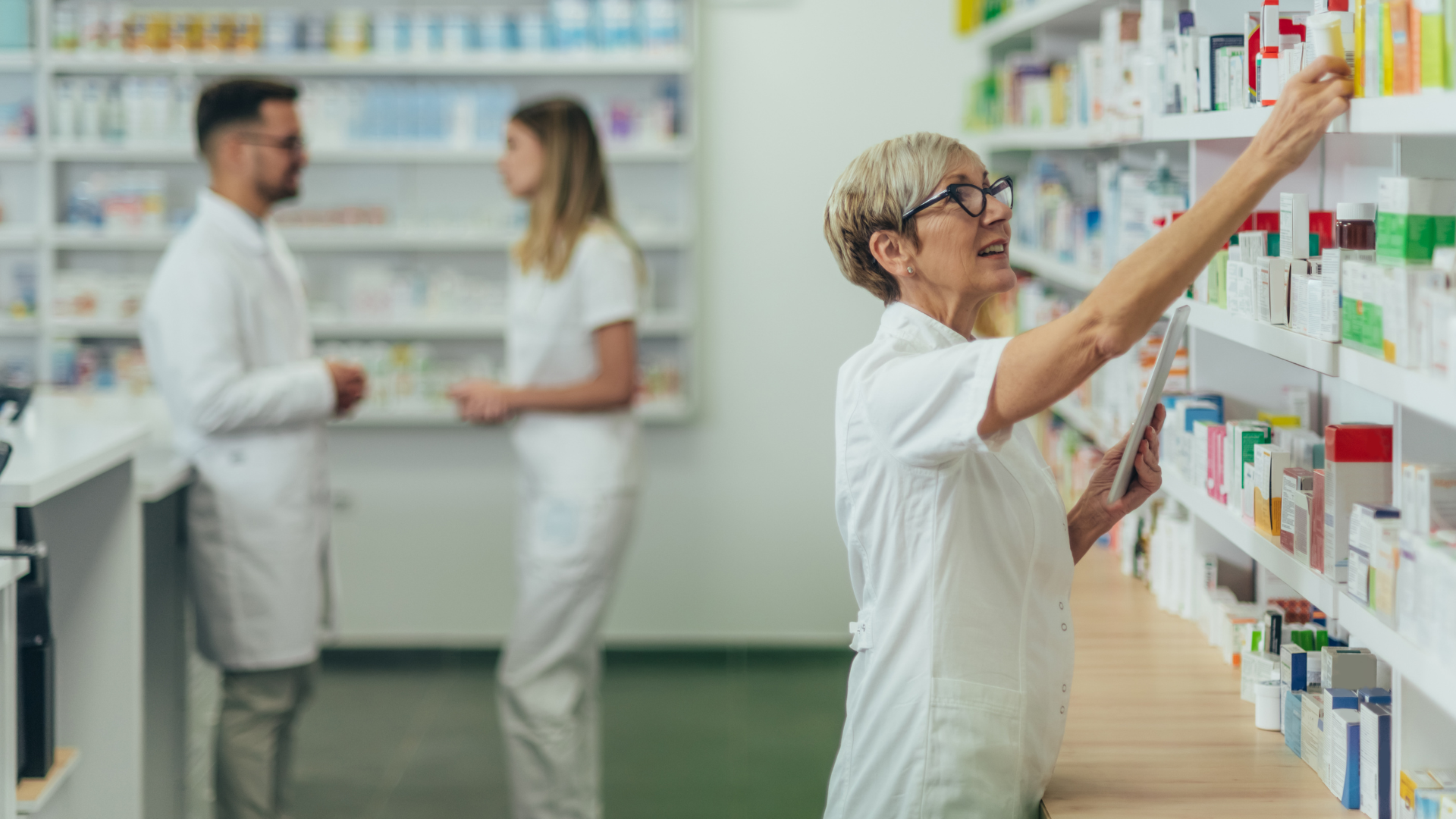 Pharmacy staff reaching for medicine