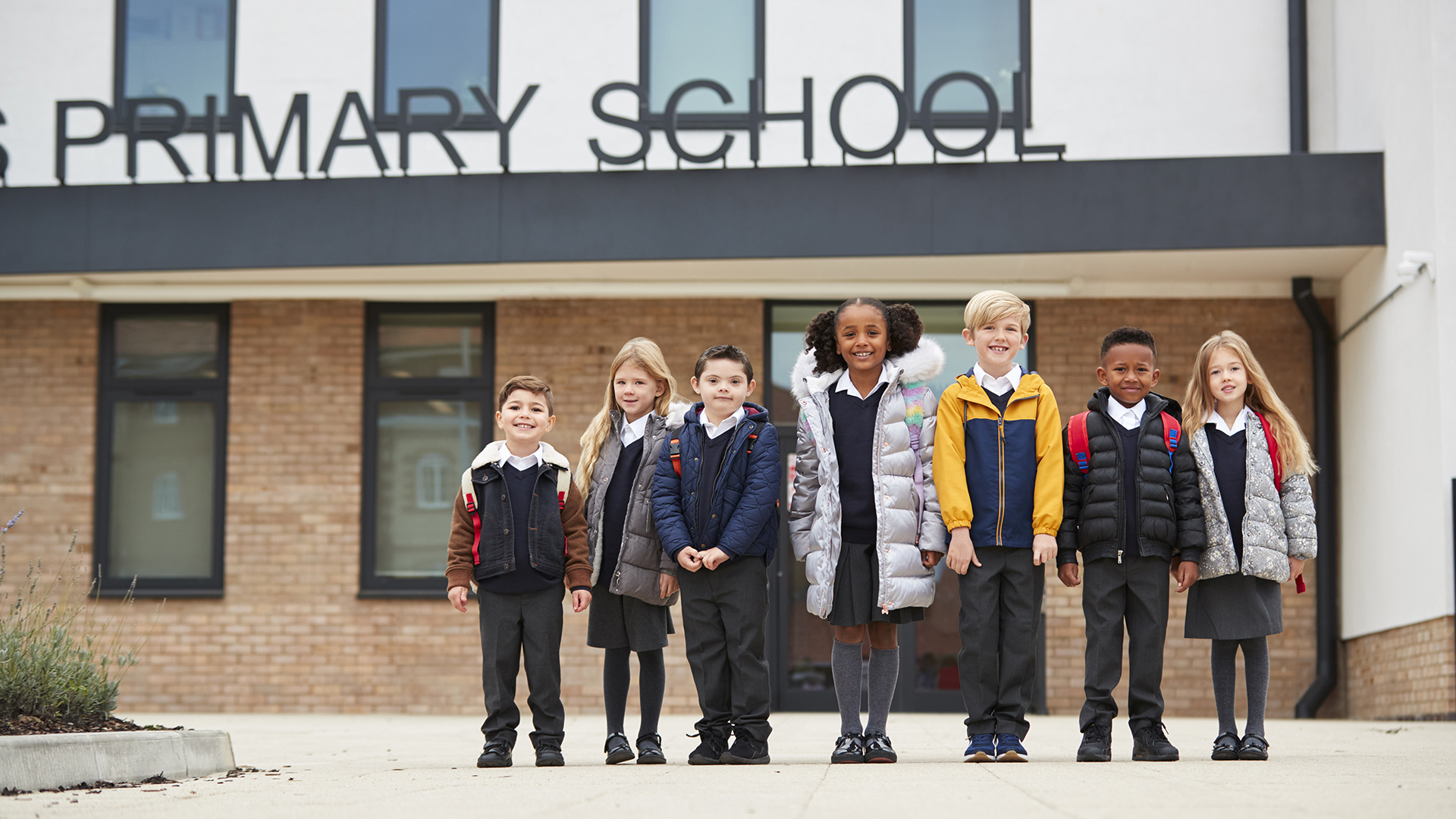 Image of Primary school kids standing in front of their school