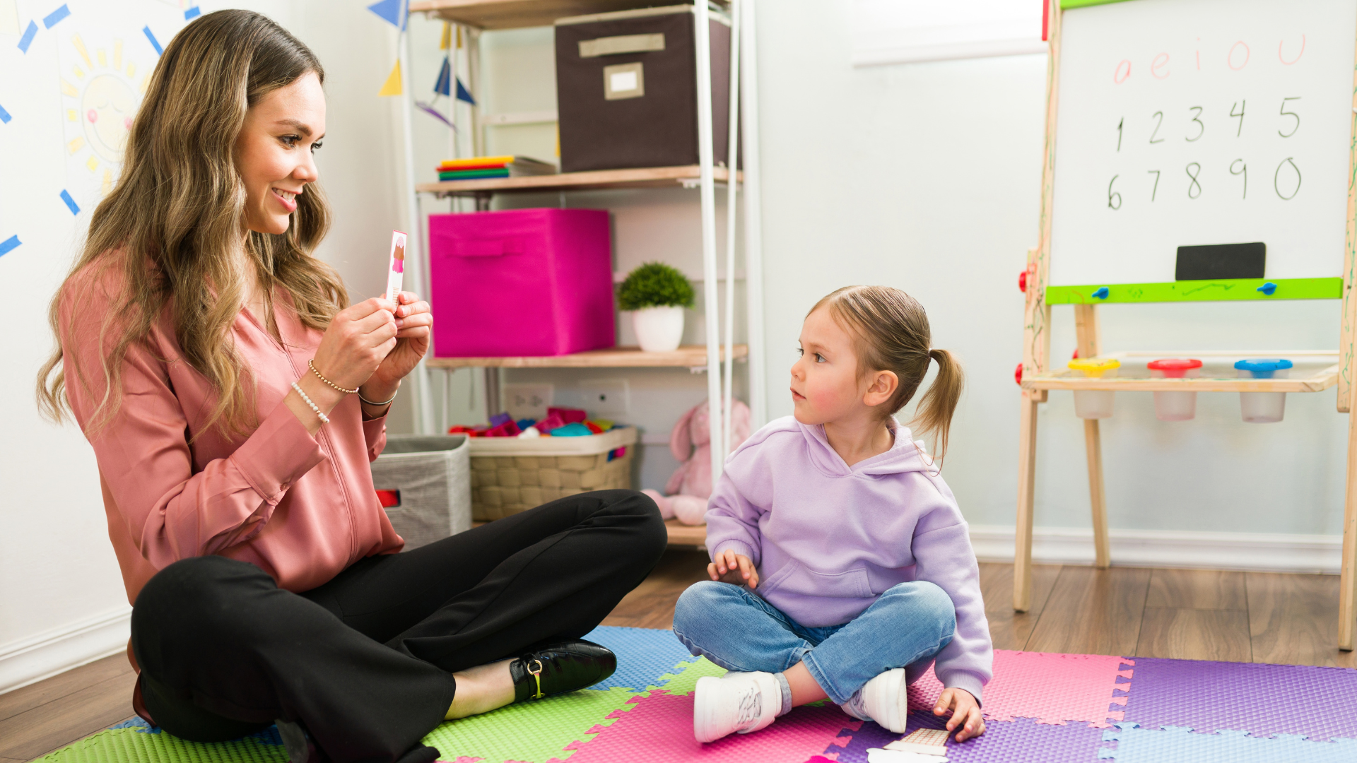 Woman playing educational game with young child