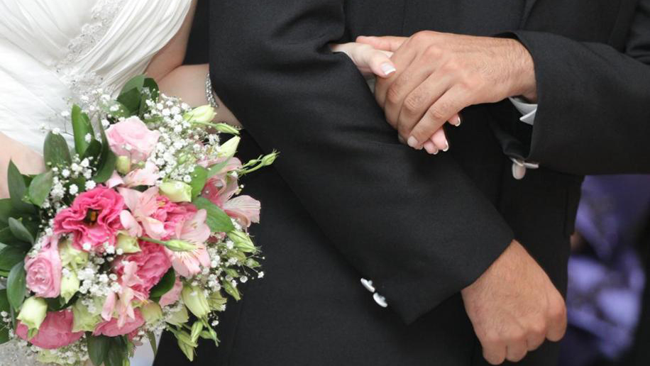 Image of bride and groom holding hands