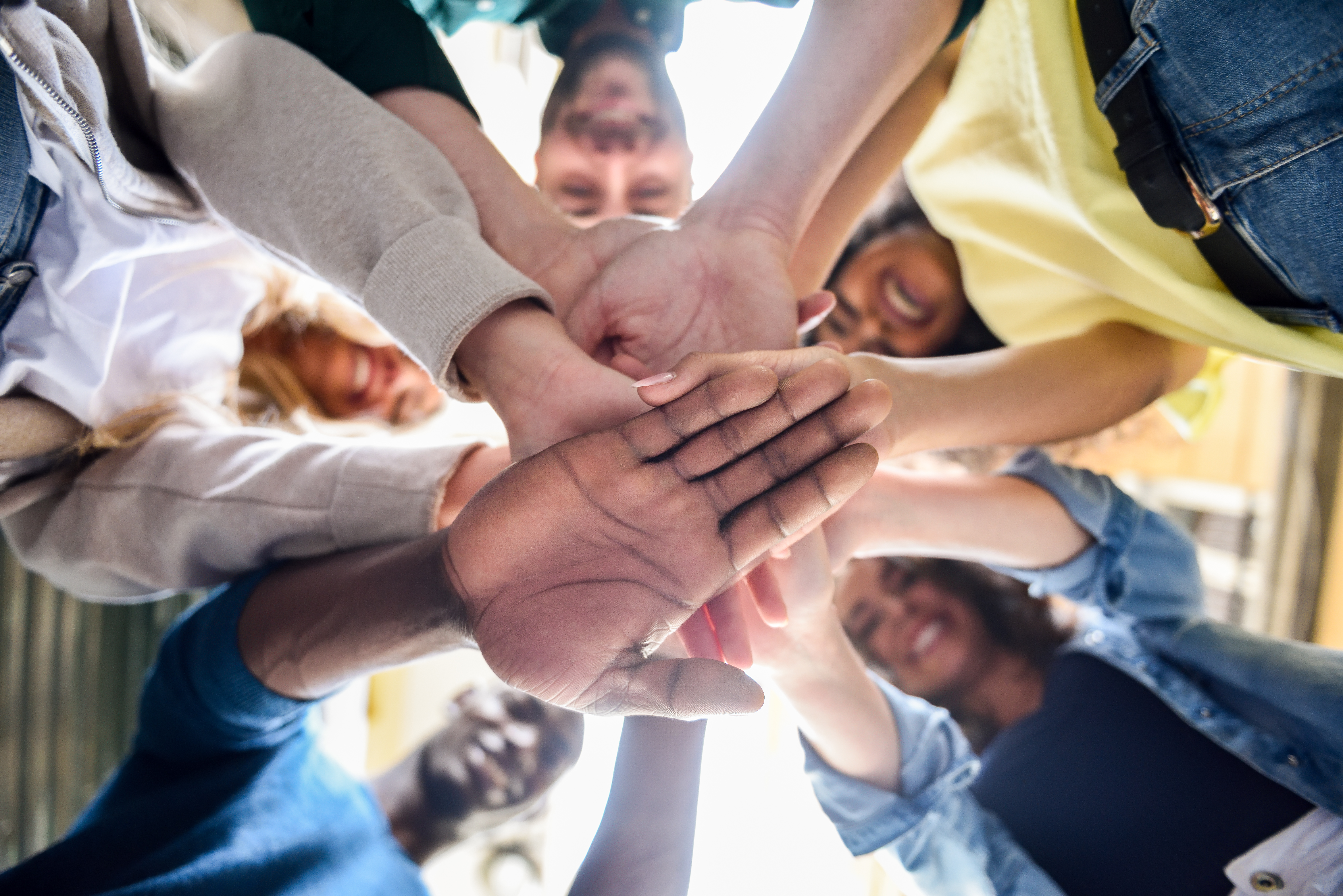 Photo of young people putting their hands together